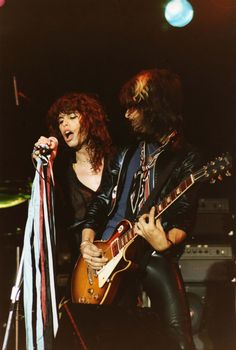 an image of two people that are playing guitar