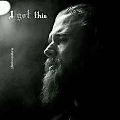 a man with long hair and beard standing in front of a light that reads 4 got this