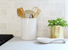 an image of a kitchen counter top with utensils in a pot and cooking utensils