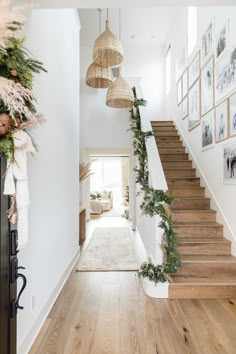 the stairs are decorated with greenery for christmas