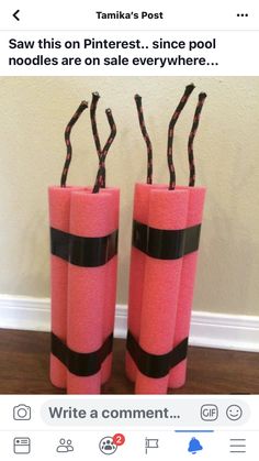 two pink vases with black ribbon on them sitting next to each other in front of a wall