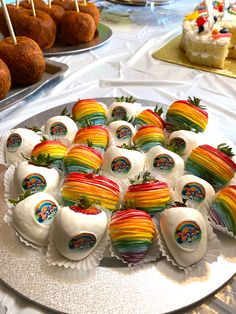 there are many rainbow desserts on the plate and in the background is cake pops