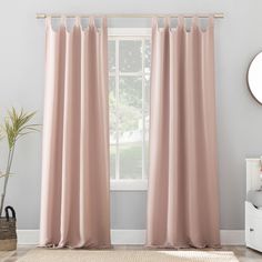 a living room with pink curtains and a rug