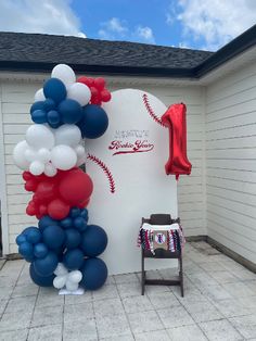 the balloon arch is decorated with red, white and blue balloons for a baseball themed birthday party