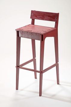 a red wooden chair sitting on top of a white floor