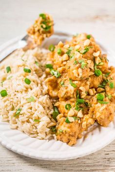 a white plate topped with rice and meat