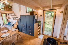 the interior of a tiny home with wooden floors and walls, windows, and furniture