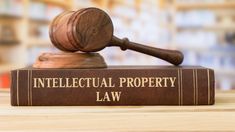 a wooden judge's gavel sitting on top of a book that reads intellectual property law