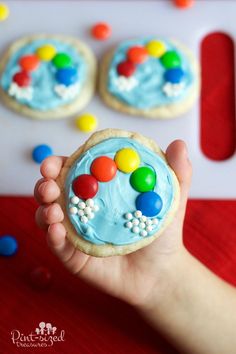 a hand holding a cookie with candy on it