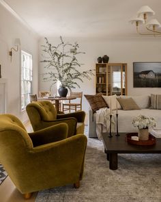 a living room filled with furniture next to a fire place and a table in front of it