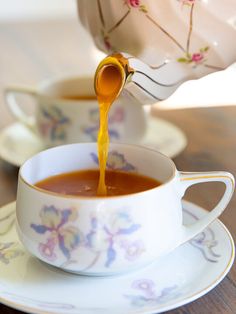 tea being poured into a cup on a saucer