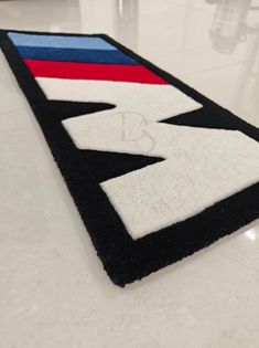 a black, white, and red rug with the letter d on it is shown