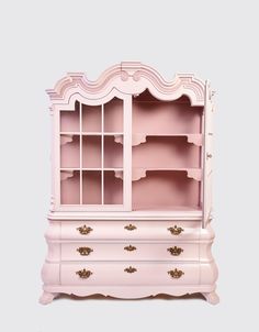 a pink dresser with shelves and drawers