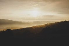 the sun shines brightly through the clouds in the mountains