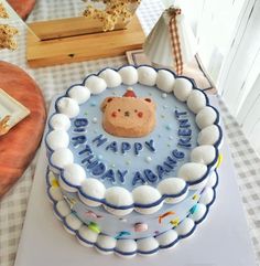 a blue and white birthday cake sitting on top of a table next to other items