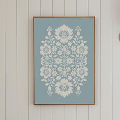 a blue and white floral print hanging on the wall