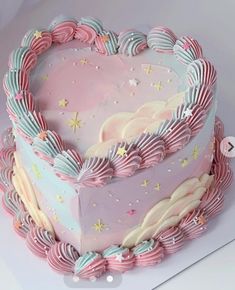 a heart shaped cake with pink frosting and stars