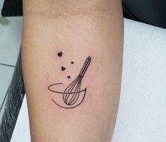 a tattoo on the leg of a woman with a whisk and hearts in it