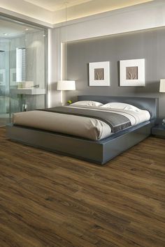 Bedroom with a wooden LVP floor and a modern style bed in the middle. Two paintings are on the wall above the bed and there is a glass wall next to the bed. Laminate Flooring In Kitchen, Luxury Vinyl Tile Flooring, Peel And Stick Floor, Vinyl Tile Flooring, Flooring Trends, Home Center