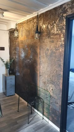 a room with a chair, table and wall in the background that has rusted paint on it