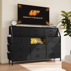 there is a large television on the wall above a dresser with drawers and an alarm clock