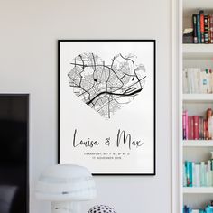 a white poster with a black heart on the wall next to a lamp and bookshelf