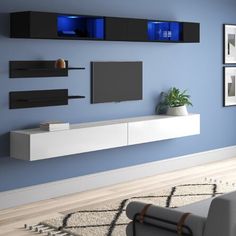 a modern living room with blue walls and white furniture, including a tv on the wall