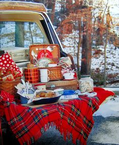 a picnic table is set up in the back of a pickup truck with plaid blankets on it