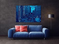 a blue couch sitting in front of a wall with a circuit board design on it