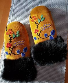 a pair of slippers with flowers and feathers on them sitting on top of a table