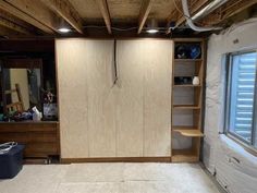 an unfinished room with wooden cabinets and shelves