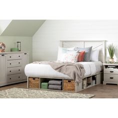 a white bed sitting next to a dresser with drawers on it's bottom shelf