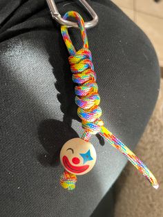 a close up of a keychain with a clown face on it's side