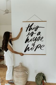 a woman standing in front of a sign that says, who do you hope?