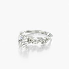 a white gold ring with an oval diamond in the center and two small diamonds on each side