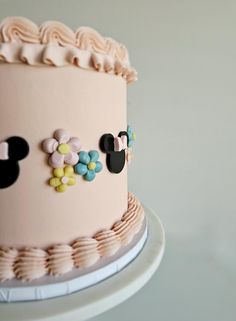 a pink cake with mickey mouse decorations on it