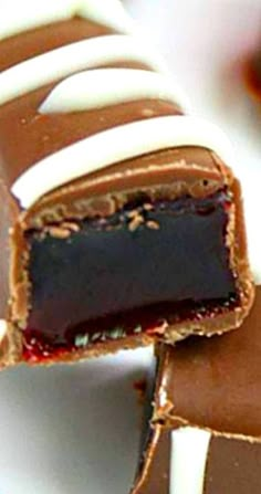 several pieces of chocolate with white and brown icing on them sitting on a plate