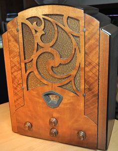 an old fashioned radio sitting on top of a wooden table