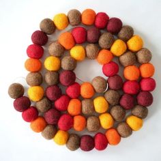 several different colors of felt balls on a white surface