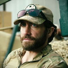 a man with sunglasses on his head and beard wearing a camo shirt, hat and sun glasses