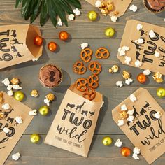 some brown paper bags filled with food on top of a wooden table next to other items