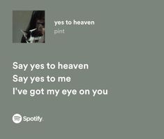 a black and white cat sitting on top of a bed next to a wall with the words say yes to heaven