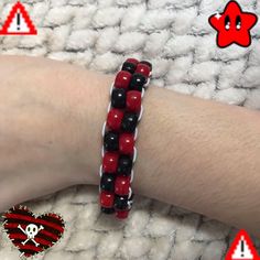 a red and black beaded bracelet on someone's arm