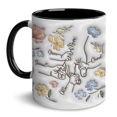 a black and white coffee mug with colorful flowers on the outside, depicting someone's love