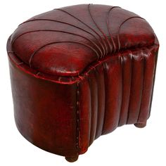 a red leather ottoman sitting on top of a wooden table