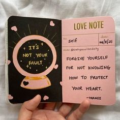 a hand holding a pink notebook with writing on it