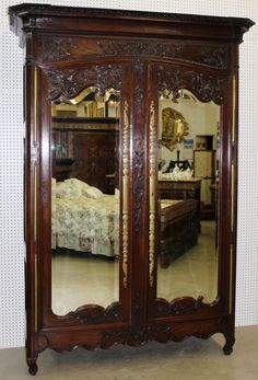 a large wooden armoire with mirrors on it