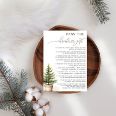 a wooden plate with a christmas tree on it next to cotton balls and pine branches