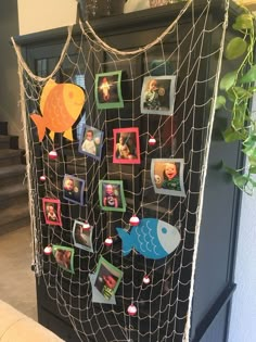 a net with pictures hanging on it and fish magnets attached to the side of it