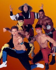 the men are posing for a photo in front of an orange and yellow background with one man wearing a sombrero